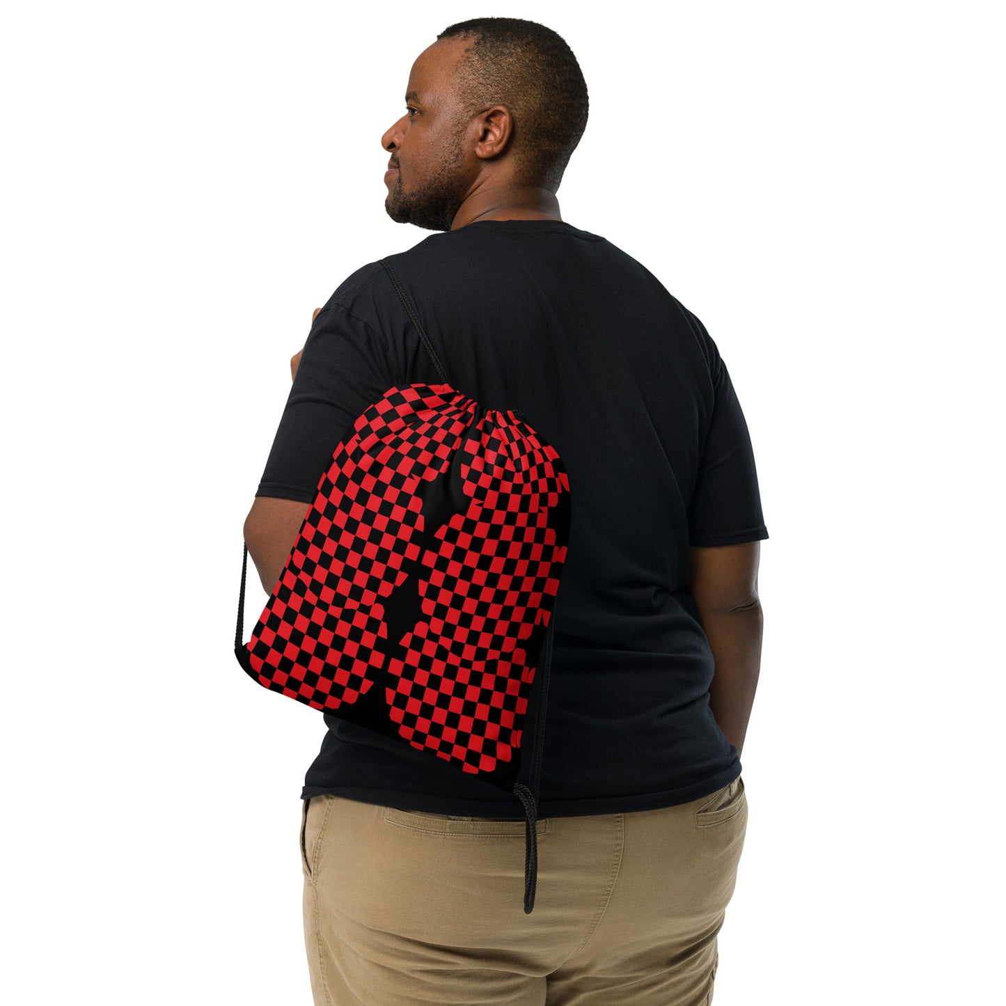 Person wearing a black t-shirt with a red and black checkered backpack.