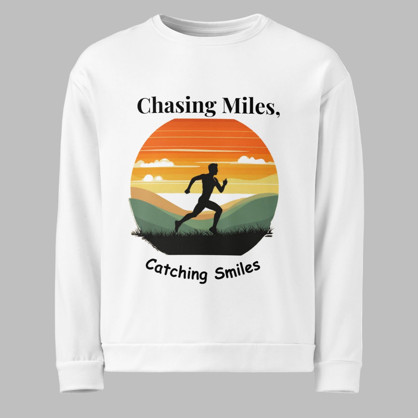 White sweatshirt with a graphic of a runner and sunset design, text 'Chasing Miles, Catching Smiles' on a white background.