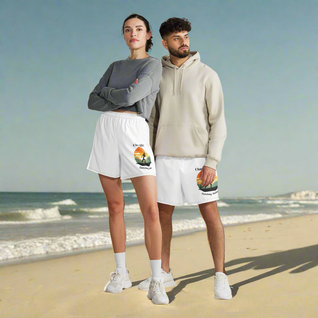 Two people wearing matching white shorts with a colorful design on a plain background