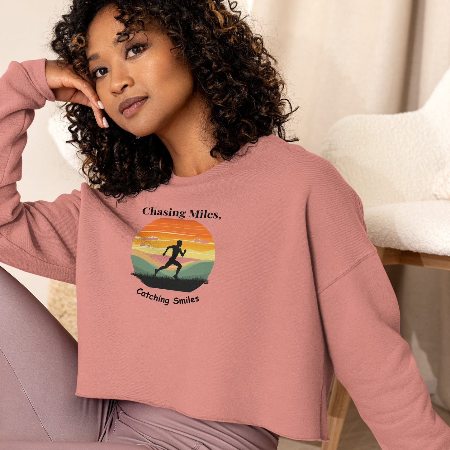 Woman wearing a pink sweatshirt with a graphic design and text.