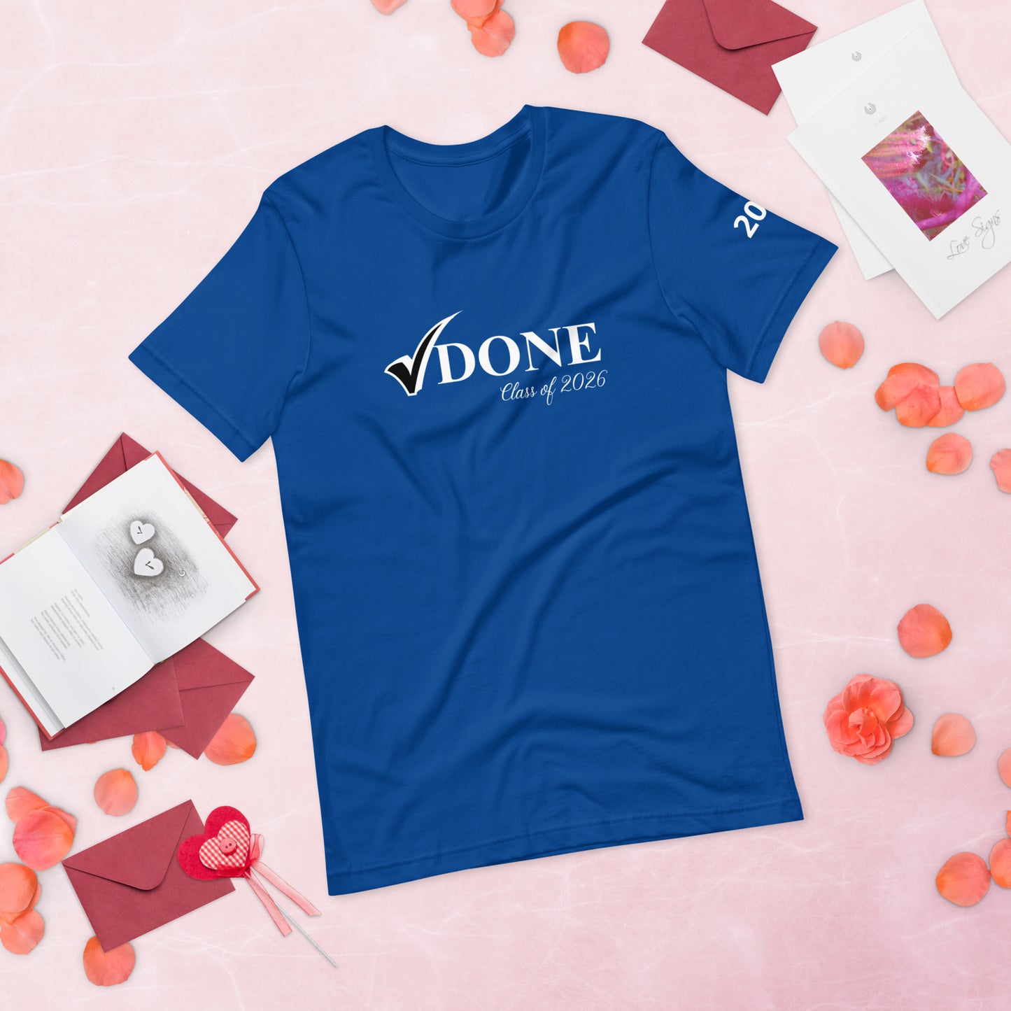 Blue t-shirt with 'DONE Class of 2026' text on a pink background with decorative elements.