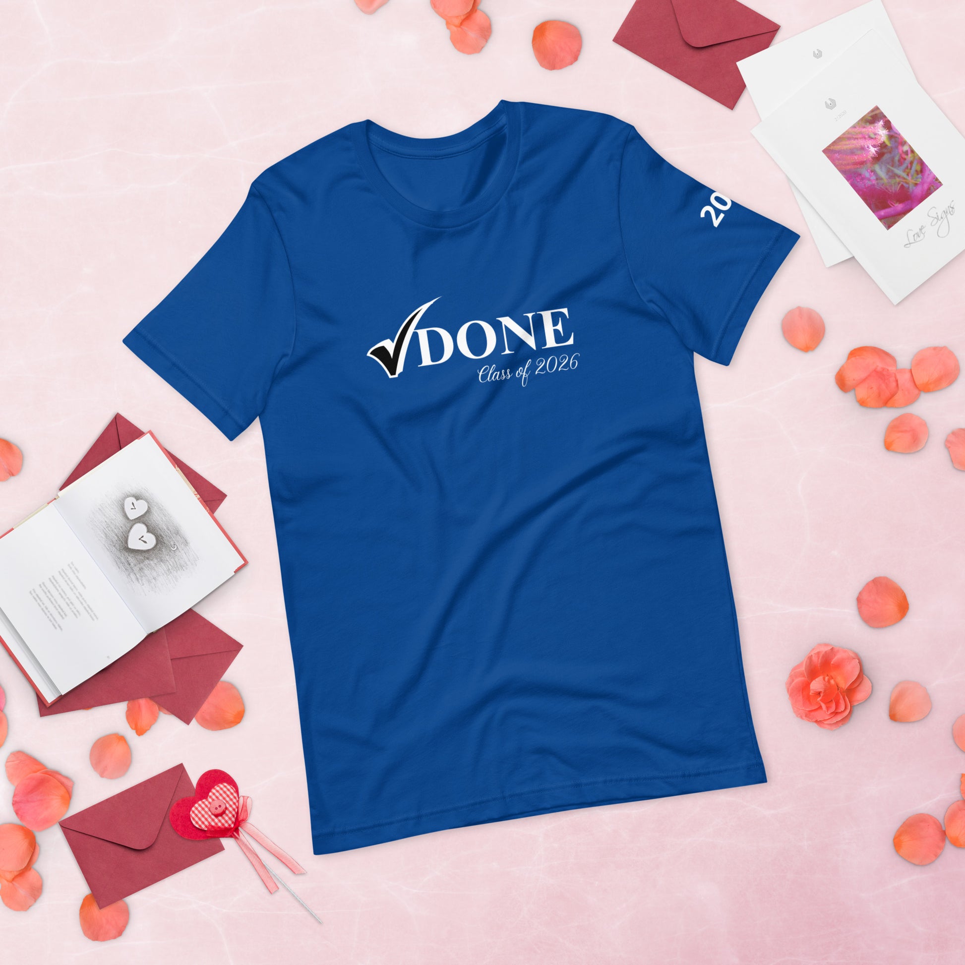 Blue t-shirt with 'DONE Class of 2026' text on a pink background with decorative elements.